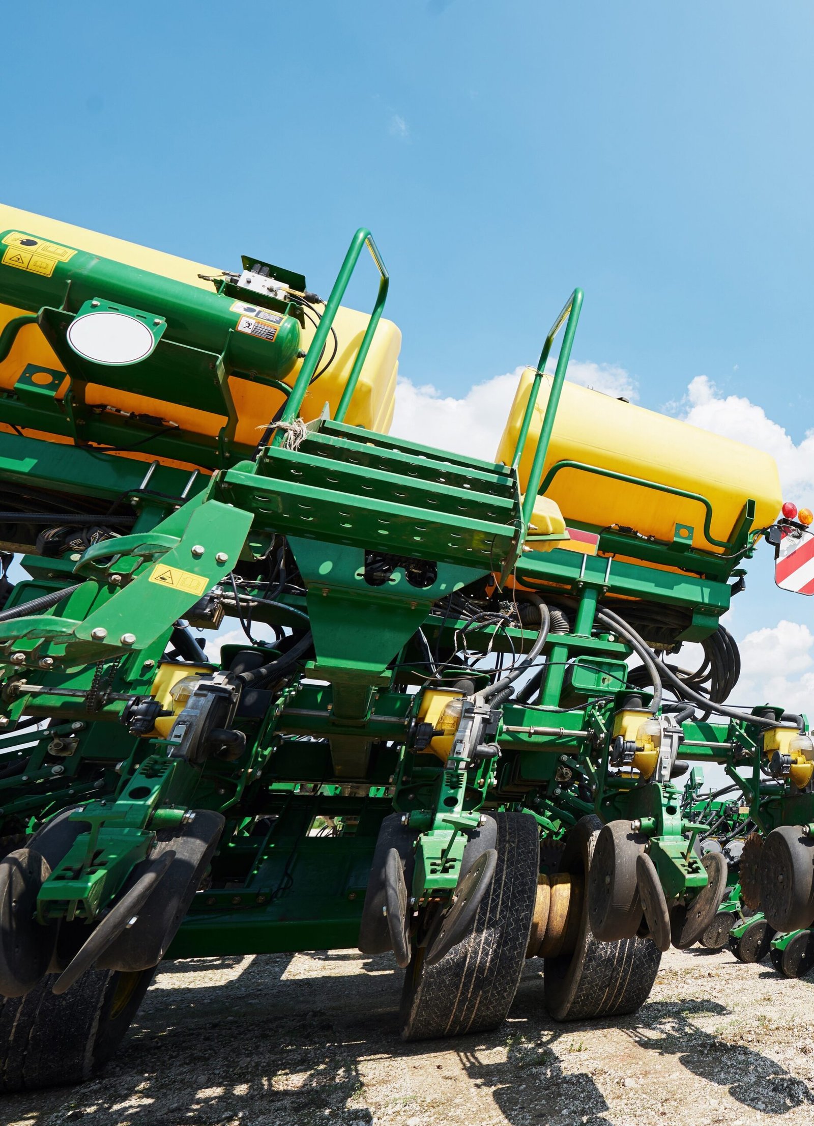 Close up of seeder attached to tractor in field. Agricultural machinery for spring works sowing, seeding